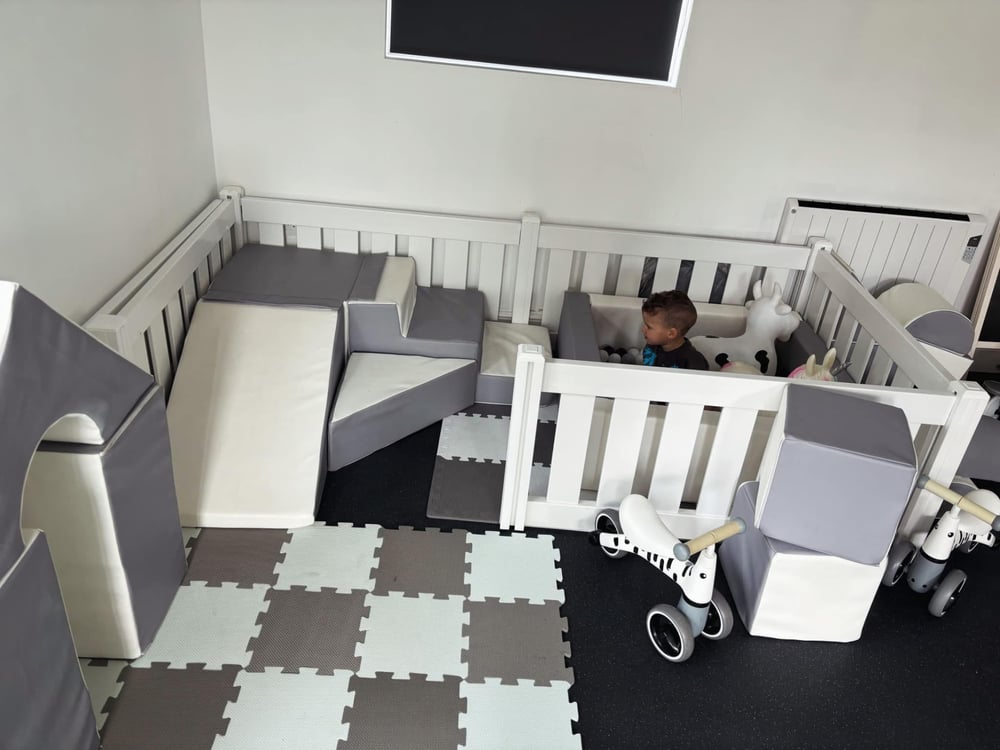 Full soft play setup with playpen surround, soft shapes and ride-on trikes